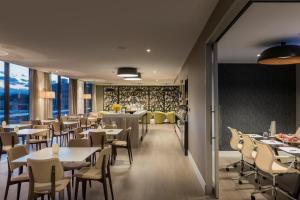 a dining room with tables and chairs and windows at PARKROYAL Parramatta in Sydney