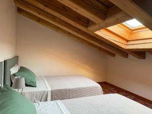 two beds in a room with wooden ceilings at CasAle 1896 in Cavaso del Tomba +43 photos
