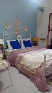 a bedroom with a large bed with blue walls at Studio Despoina in Skala Kallonis