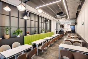 a row of tables and chairs in a room with plants at Gangnam Artnouveau City in Seoul