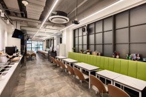 a restaurant with tables and chairs and a green wall at Gangnam Artnouveau City in Seoul