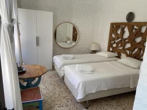 a hotel room with two beds and a mirror at Alaçatı Ala Hotel - Special Category in Alaçatı