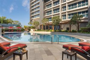 a swimming pool in front of a building at Park Rotana Abu Dhabi in Abu Dhabi