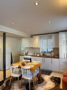 a kitchen with a wooden table and white cabinets at To Petrino apartment in Kyparissia