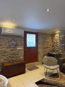 a living room with a wooden door and a chair at To Petrino apartment in Kyparissia