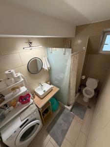 a small bathroom with a washing machine and a sink at To Petrino apartment in Kyparissia
