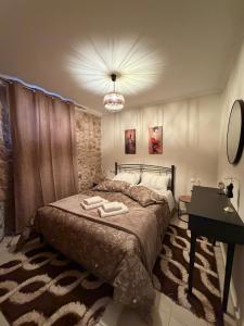 a bedroom with a bed and a desk and a lamp at To Petrino apartment in Kyparissia
