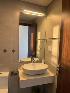 a bathroom with a sink and a mirror at VEC Homes - Triển lãm VEC Đông Anh - 2 Phòng ngủ view sông Hồng in Dong Anh +7 photos