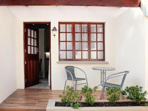 a patio with two chairs and a table in front of a house at Belle Vue in Queenstown