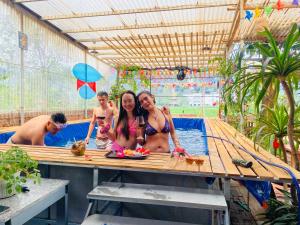 a group of people sitting at a table in a pool at Big J gest house in Ninh Binh