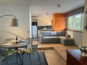 a living room with a couch and a table and chairs at Inaya Apartment in Oggebio