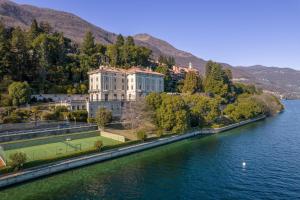a building on the side of a river with a tennis court at Inaya Apartment in Oggebio