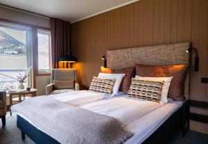 a bedroom with a large bed and a chair at Flåmsbrygga Hotel in Flåm +41 photos