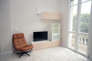 a living room with a chair and a television at Luxury Suite ATHENA - MINERVA in Reggio di Calabria