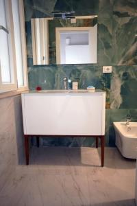 a bathroom with a white sink and a mirror at Luxury Suite ATHENA - MINERVA in Reggio di Calabria