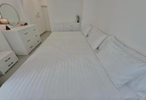 a large white bed in a white bedroom at PHAM Homes in Hai Phong