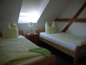 two twin beds in a room with a roof at Lindenhof Helmke in Schellerten