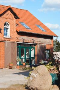 a brick house with a window and a rock at Lindenhof Helmke in Schellerten