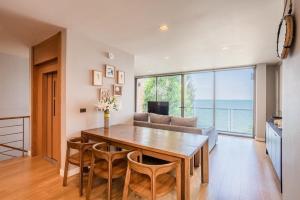 a living room with a table and a couch at Sandbox Beachfront Villa 6 in Ban Krathing Lai