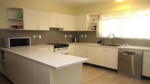 a kitchen with white cabinets and a white counter top at Del Haven Holiday House in Arcadia