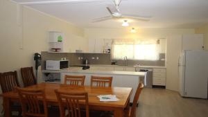 a kitchen with a table and a kitchen with a refrigerator at Del Haven Holiday House in Arcadia