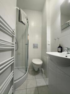 a white bathroom with a toilet and a sink at Apartament z KLIMATYZACJĄ - ul Plebiscytowa 19 - darmowy parking in Opole