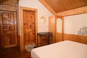 a bedroom with a bed and a wooden door at Romantic loft with mountain view in manali in Haripūr