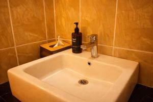 a bathroom sink with a soap dispenser on top of it at Tendan Residence in Legian +15 photos