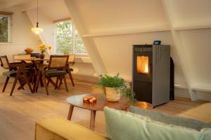 a living room with a fireplace and a table at Boshuisje Rekem - Nirvana in Lanaken