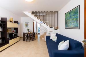 a living room with a blue couch and a staircase at Villino Joy in Stintino