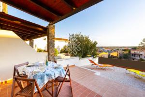a patio with a table and chairs on a balcony at Villino Joy in Stintino