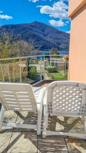 two white benches sitting on a balcony with a view at Casa Belfiore in Maccagno Superiore