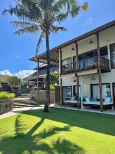 a house with two palm trees in front of it at Anapuri Villas in Ketewel