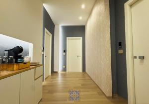 a hallway leading to a room with a kitchen and a door at Passo Lento Charme Rooms in Gravina in Puglia