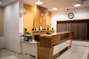 an office with a reception desk with a clock on the wall at IRA by Orchid, Nashik in Nashik