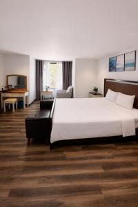 a hotel room with a large bed and a couch at Camly Resort DaLat in Ấp Ða Lợi