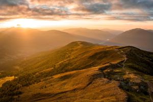 an image of the sun setting on a mountain at Alpin Peaks in Turracher Hohe