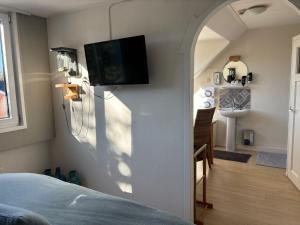 a bedroom with a tv hanging on the wall at Bed & Breakfast d'Ouwe Smidse in Kamperland