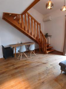 a living room with a wooden table and stairs at Apartment King Louie in Prien am Chiemsee