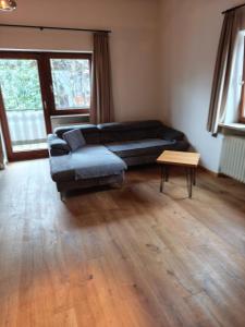 a living room with a black couch and a table at Apartment King Louie in Prien am Chiemsee +1 photo