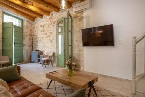 a living room with a couch and a tv on a wall at MERAKI residence in Atsipopoulo