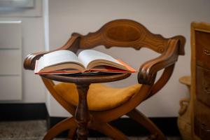 an open book sitting on a wooden chair at La casa di Ros in Perinaldo