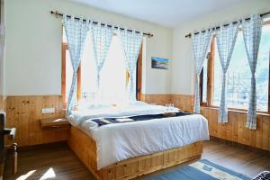 a bedroom with a large bed with a window at Akari Inn in Haripūr