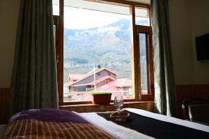 a bedroom with a bed and a large window at Akari Inn in Haripūr