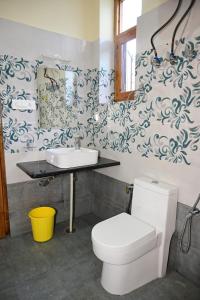 a bathroom with a toilet and a sink at Akari Inn in Haripūr