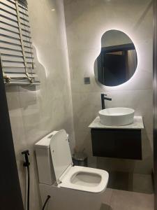 a bathroom with a white toilet and a sink at Hirolagos in Bamgbose