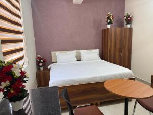 a bedroom with a bed and a table and chairs at JMD Zoom Plaza Hotel in Farrukhnagar