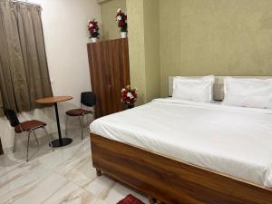 a bedroom with a bed and a table and chairs at JMD Zoom Plaza Hotel in Farrukhnagar +2 photos