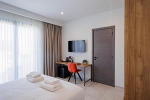 a bedroom with a bed and a desk with a monitor at Zyra Hotel St Julians - Adults only in St. Julianʼs