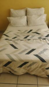 a large bed with white sheets and pillows at METINAT GUEST HOUSe in Groblersdal